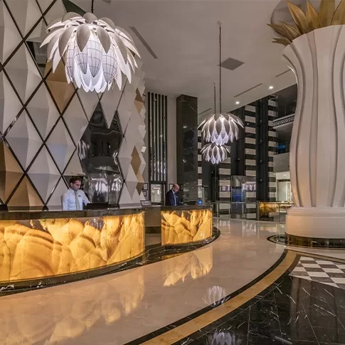 The grand lobby of a luxury hotel, highlighted by a stunning large chandelier that adds sophistication to the space.