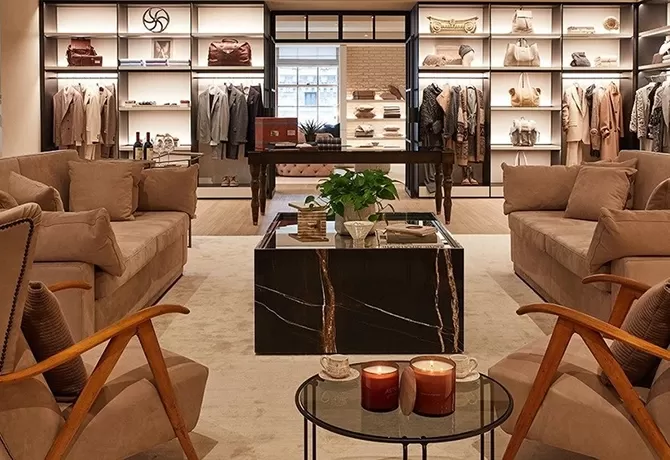Luxury seating area within retail store with clothes, accessories and bags