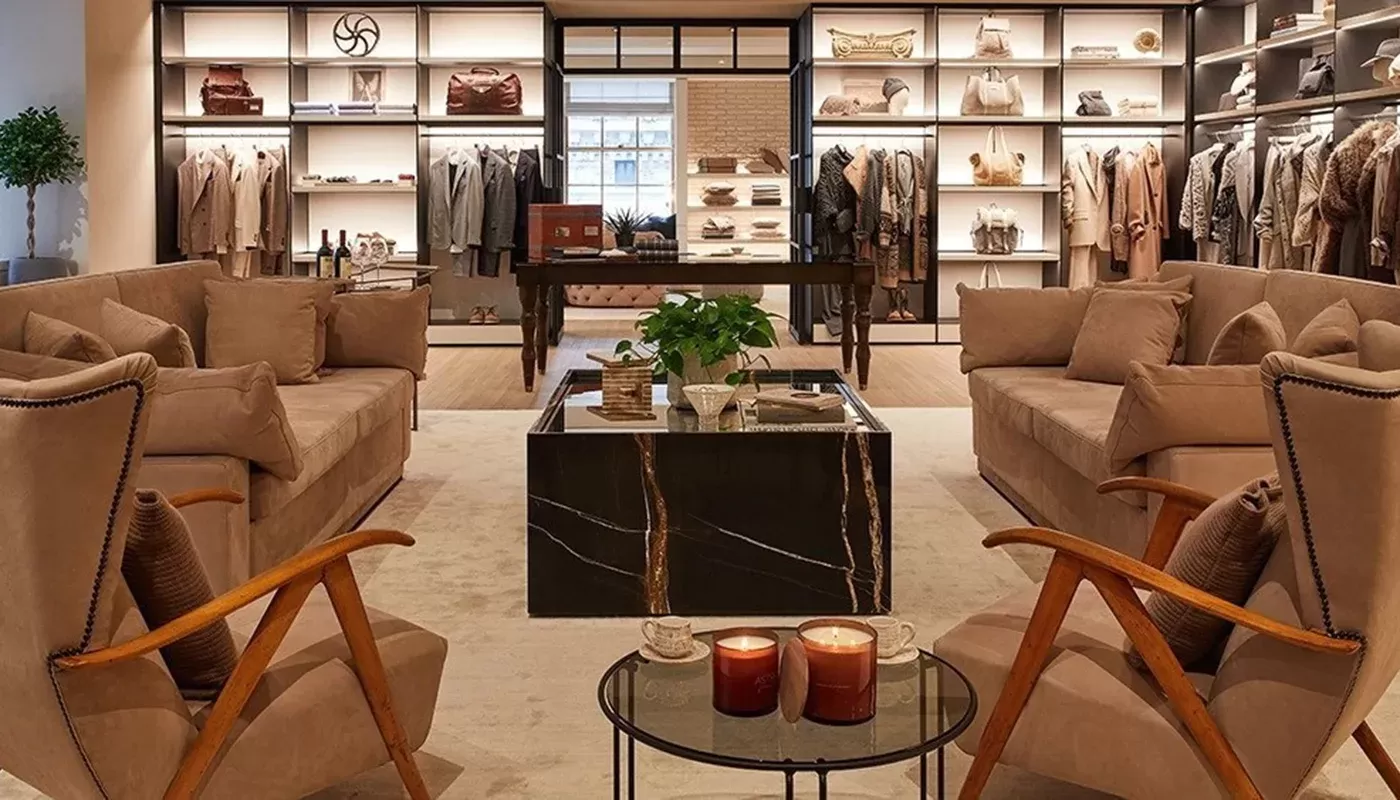 Luxury seating area within retail store with clothes, accessories and bags