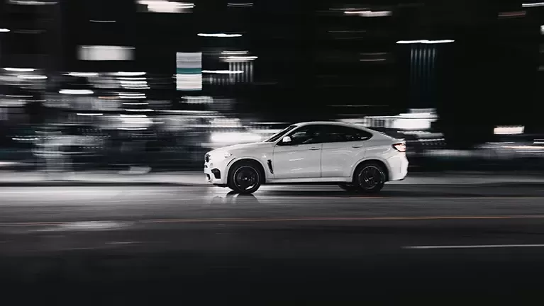 White 4x4 BMW driving in long exposure background