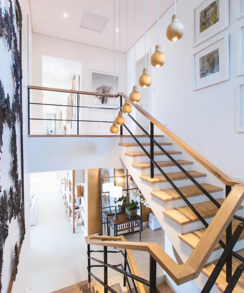 A staircase featuring a white wall and elegant wooden railings, creating a clean and inviting atmosphere.