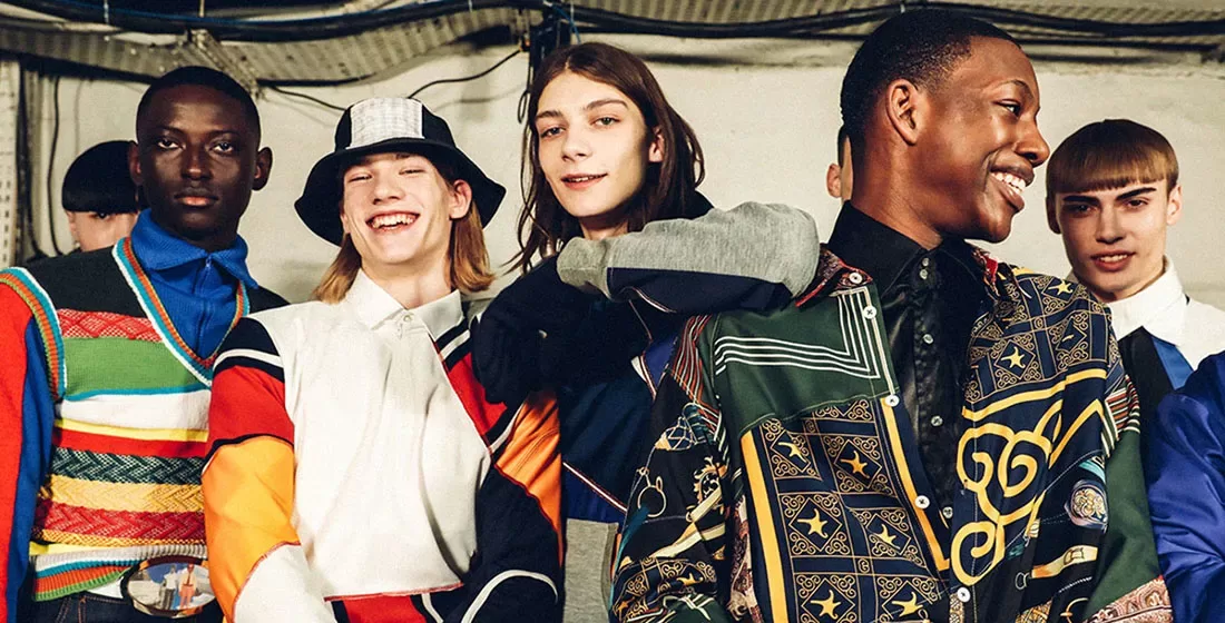 Group of male models posing and smiling in fashion clothing