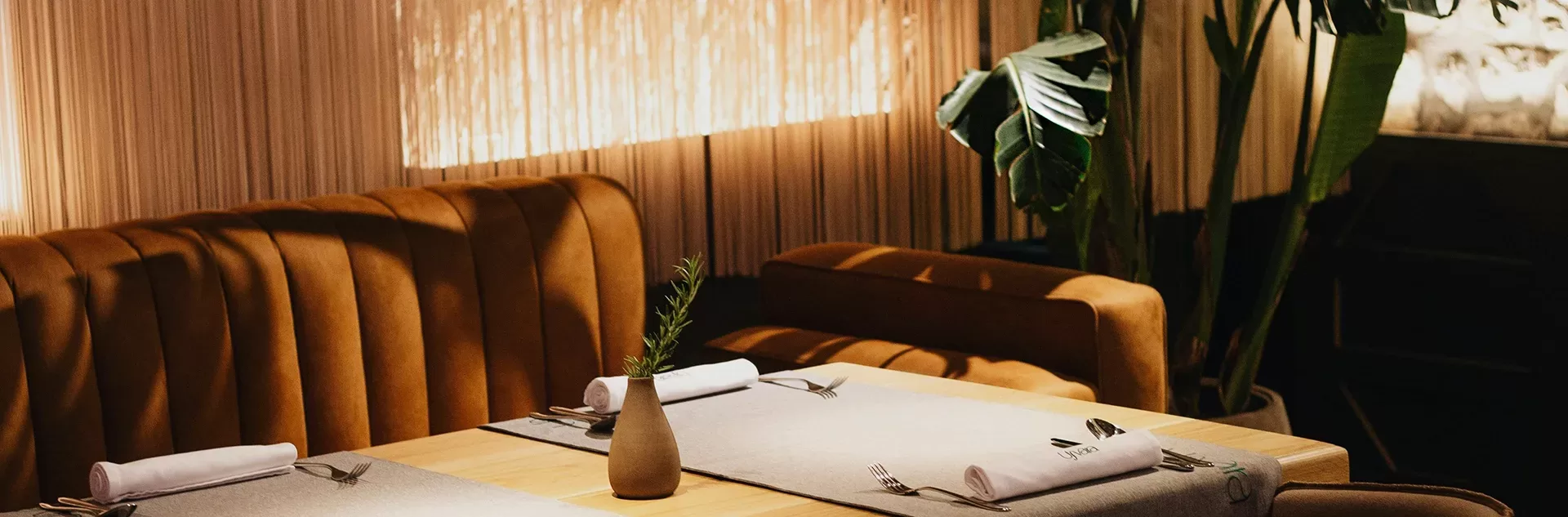 A wooden table with a polished surface, surrounded by four chairs in a well-lit dining area.