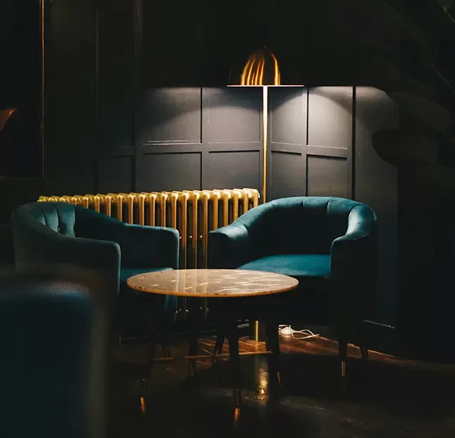 A cosy restaurant interior featuring elegant décor, tables set for dining, and warm ambient lighting.