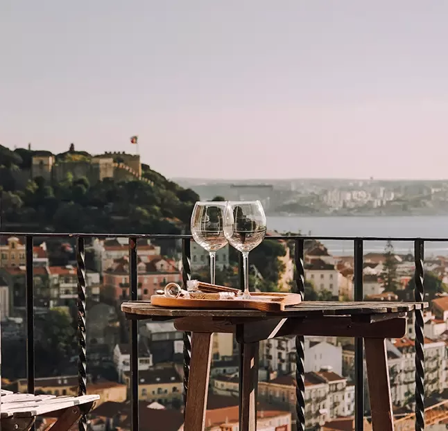 A pair of elegant wine glasses resting on a balcony, overlooking a beautiful view, perfect for a relaxing evening.
