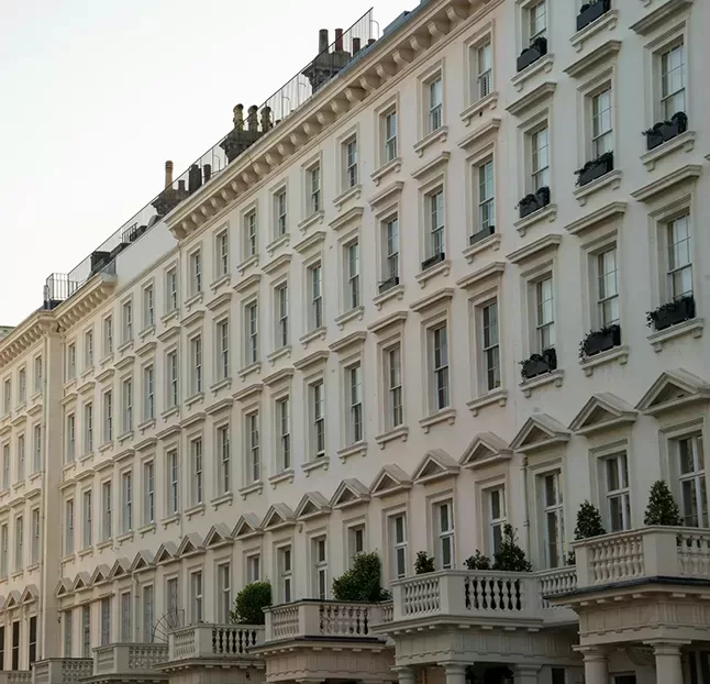 A row of elegant white buildings featuring multiple balconies, showcasing a clean and modern architectural style.