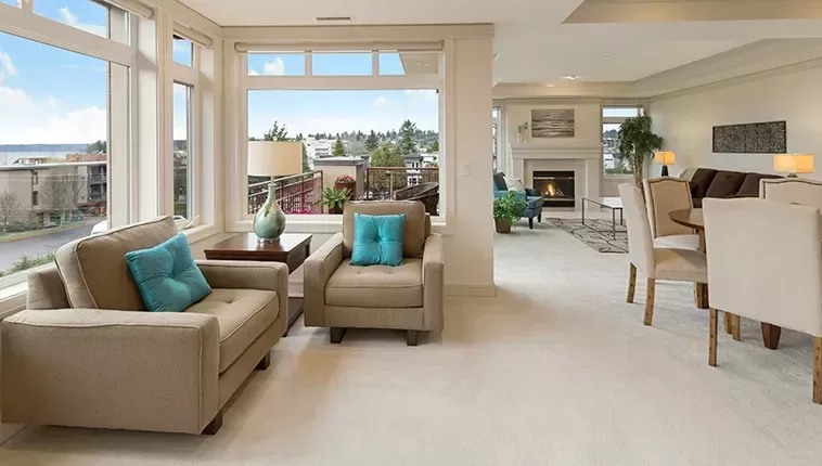 A cosy living room featuring large windows that showcase a stunning view of the ocean beyond.