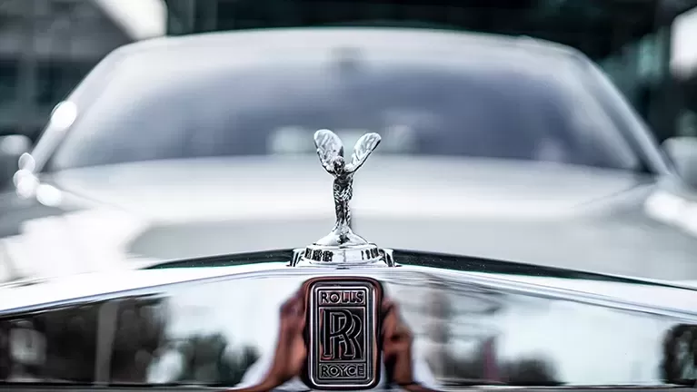 Front of silver Rolls Royce car with branded bonnet ornament