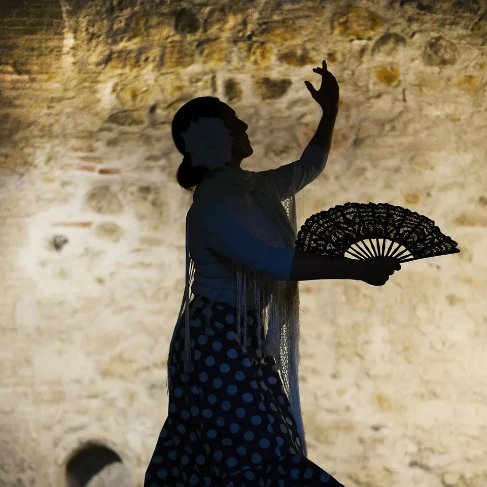 Women dancing the flamenco with a fan in a cave