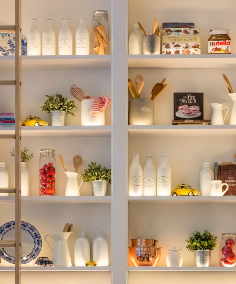 A diverse shelf displaying various food items and kitchen utensils, showcasing an organized culinary collection.