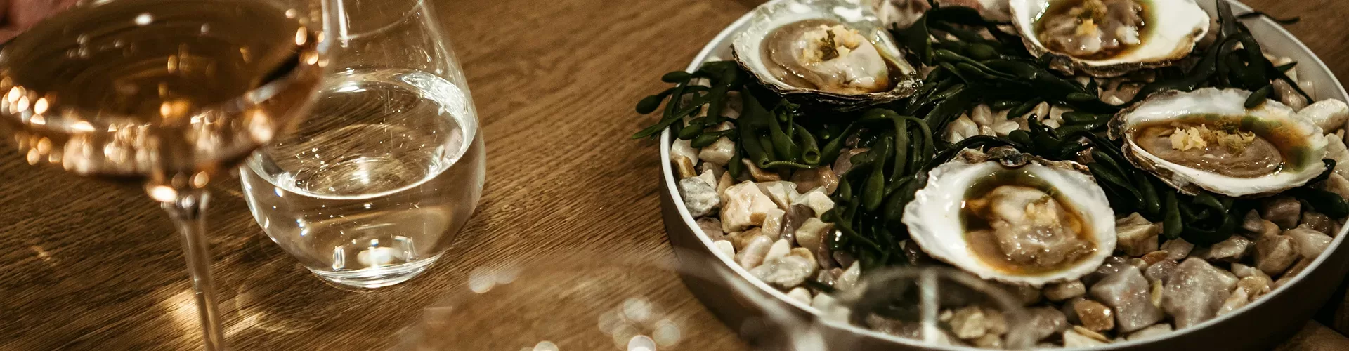 Aerial view of a dinner table with oysters and wine glasses.