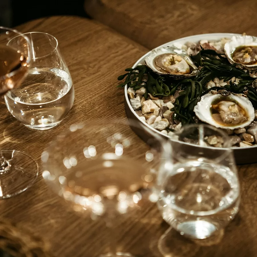 Aerial view of a dinner table with oysters and wine glasses.