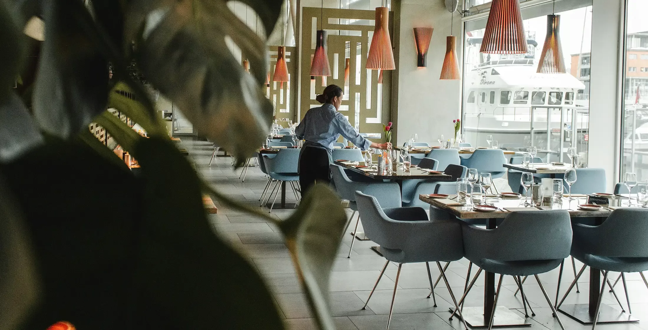 Waitress setting tables in luxury restaurant