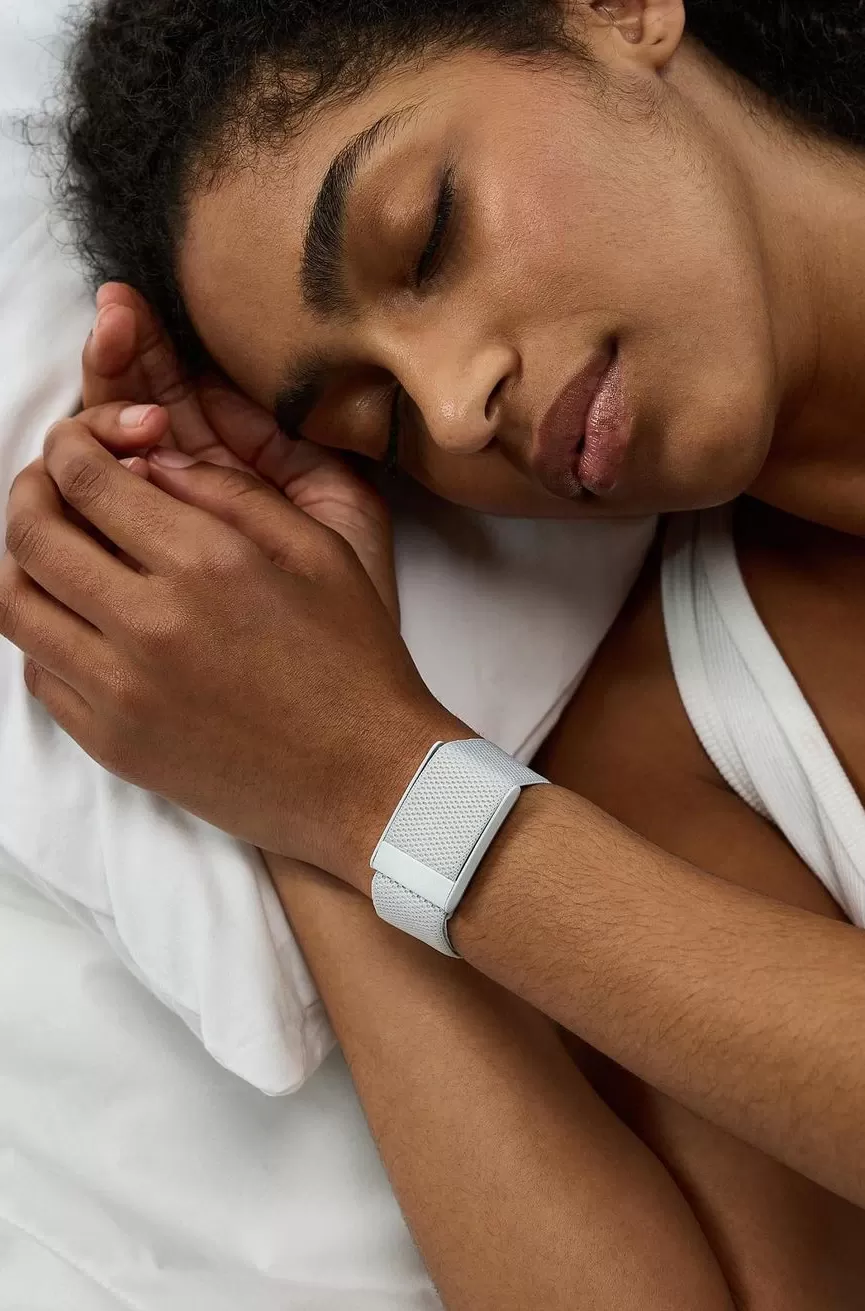 Women sleeping on a pillow wearing a wearable tech watch