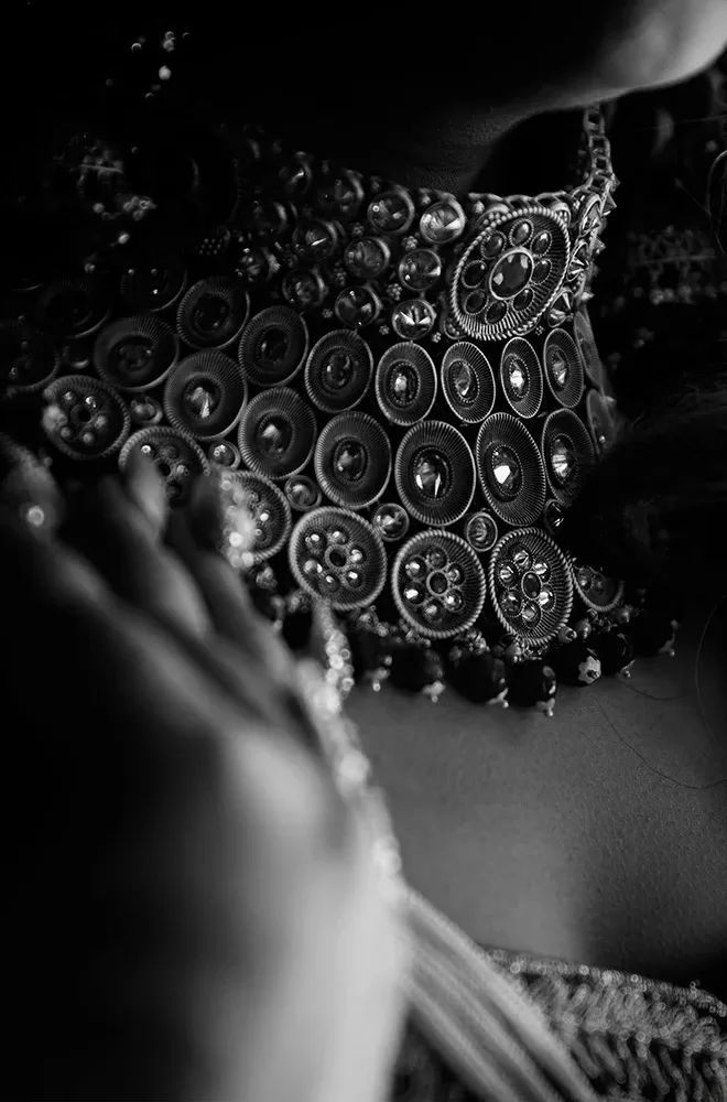 Black and white photo of a glamorous woman wearing a beautiful Indian-wedding inspired statement choker, and neckpiece of jewellery.