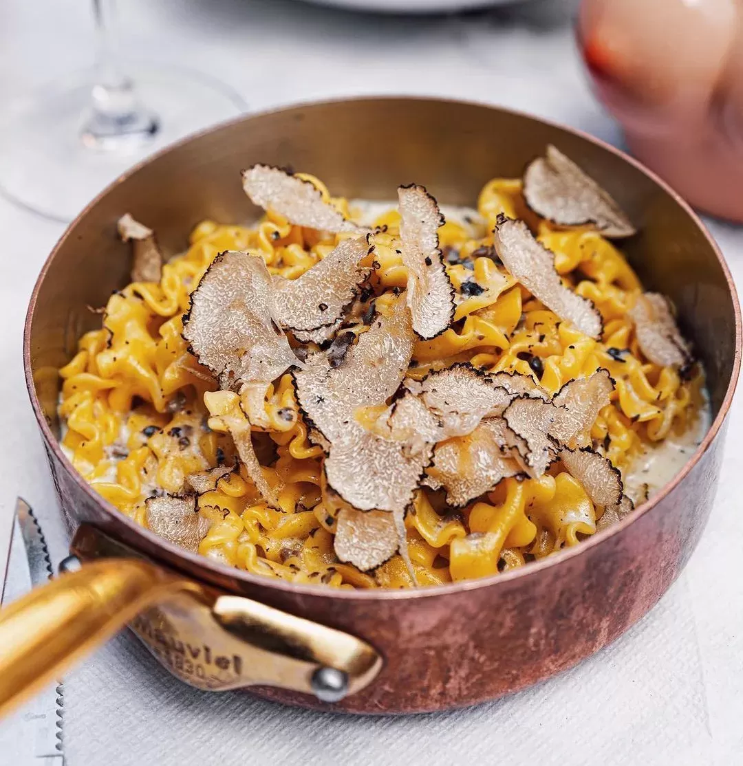 Spaghetti al tartufo with black truffle shavings served in a pot at Jacuzzi
