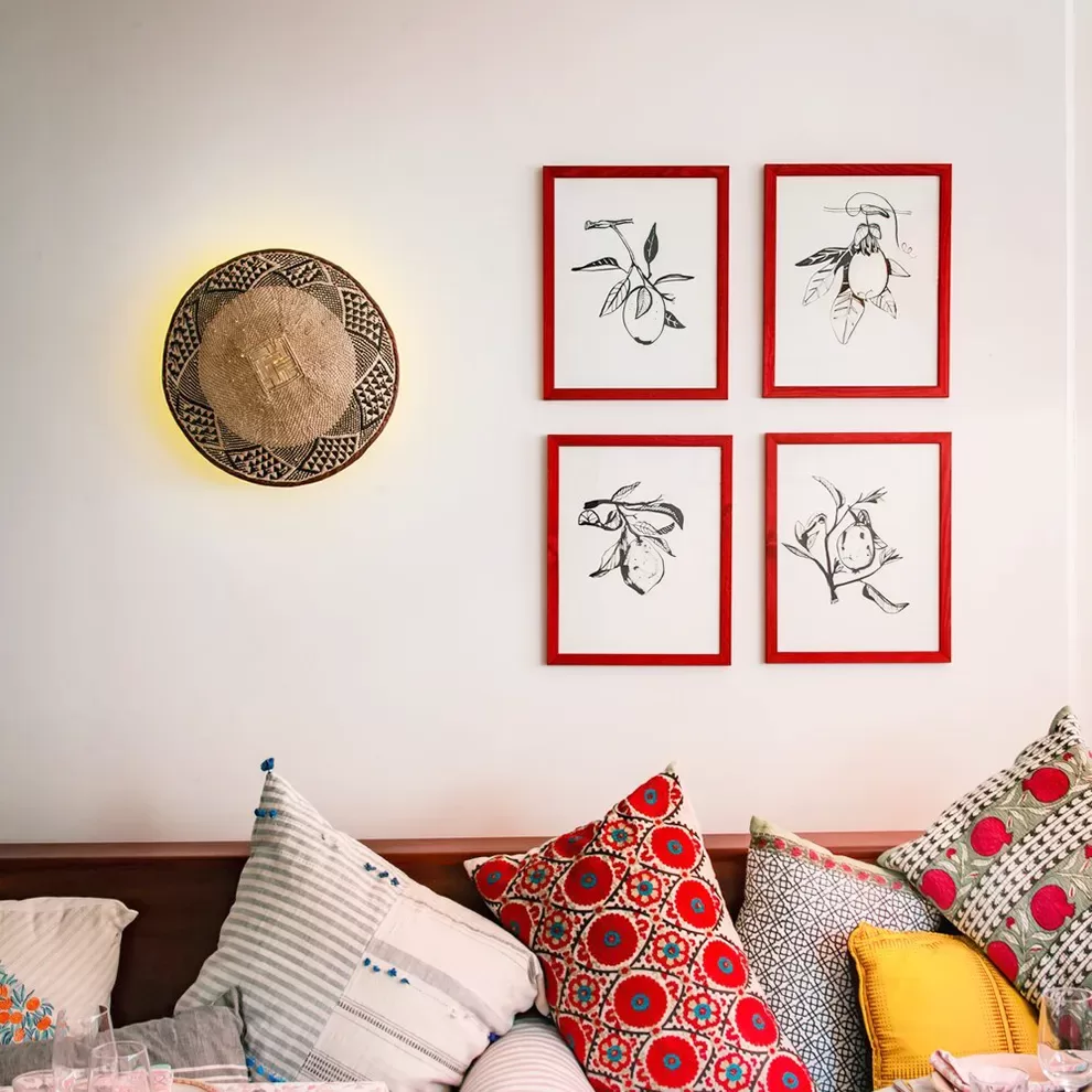 Colourful and cosy seating area of Jikoni, with bird line drawings on the walls, London