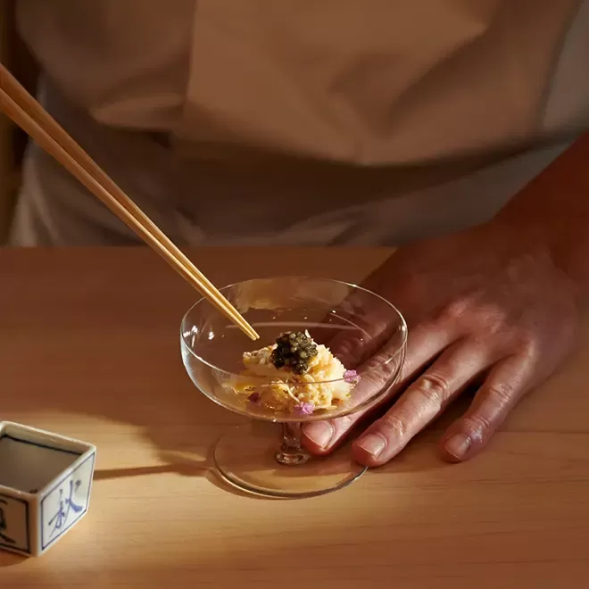 Chef Shinji Kanesaka beautifully crafting a dish in a martini glass with chopsticks at Sushi Kaneska, Mayfair, London