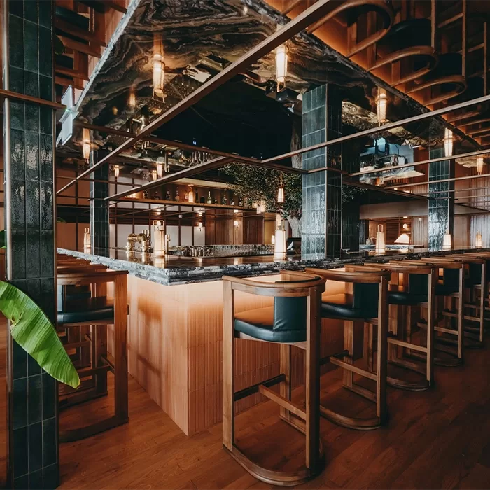 A beautifully crafted wooden bar at Marius Monaco in Monte Carlo, enhanced by an abundance of greenery for a lively setting in Monte Carlo.