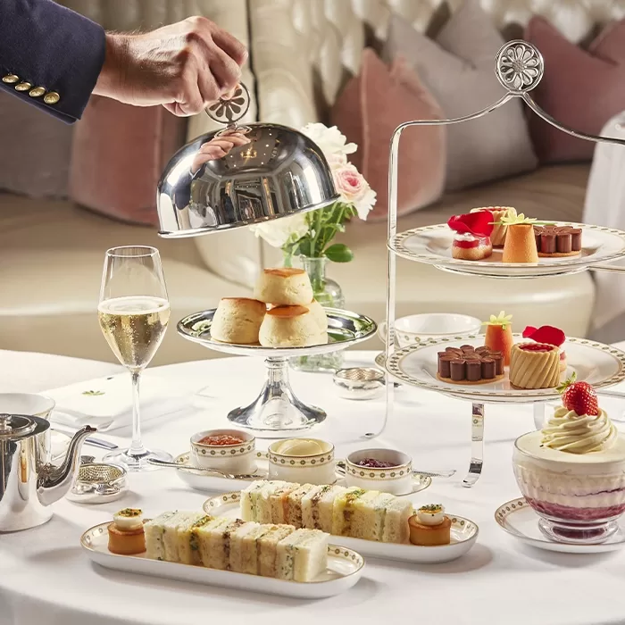 Elegant afternoon tea set at Palm Court, The Langham, featuring fine china, a selection of sandwiches and pastries, and a serene ambiance.