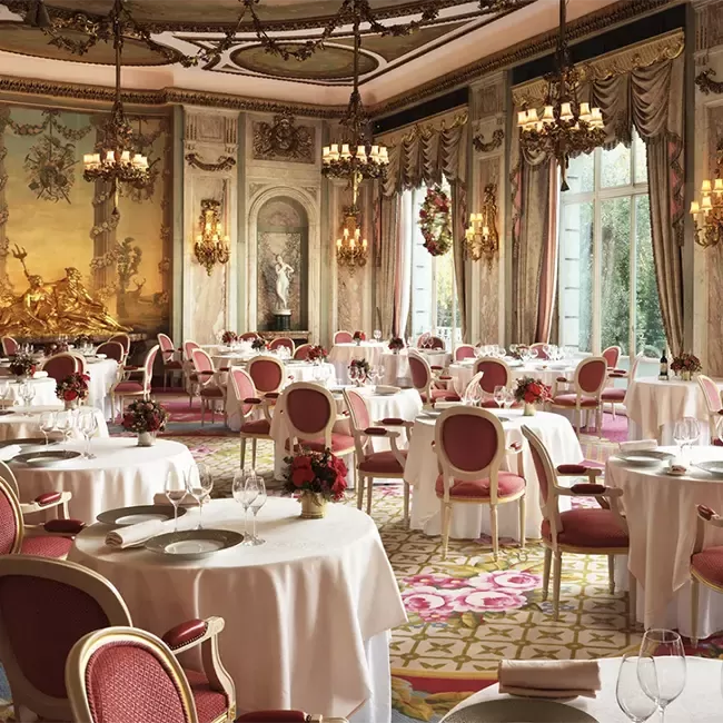 Elegant dining room at The Ritz London, adorned for Christmas, showcasing luxurious decor and festive ambiance.